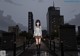 A girl in a school uniform standing on a bridge.