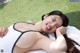 A woman in a white bathing suit laying on a towel.