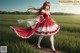 A woman in a red and white dress standing in a field.