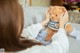 A woman sitting on a couch holding a teddy bear.