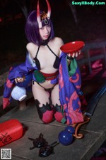 A woman in a kimono holding a red bowl and a sword.